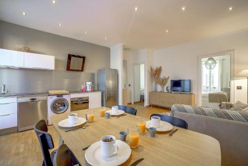 Il dispose d'une cuisine et d'un salon avec une table et des chaises en bois. dans l'établissement Maison Bianchi - Chauvain Place Massena, à Nice