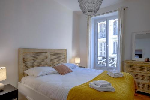 une chambre avec un grand lit avec deux serviettes dessus dans l'établissement Maison Bianchi - Chauvain Place Massena, à Nice