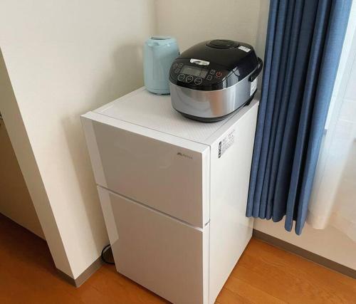 a toaster sitting on top of a white cabinet at 中島公園徒歩3分、Susukino（薄野）内、格安有料駐車場あり(205号室） in Sapporo
