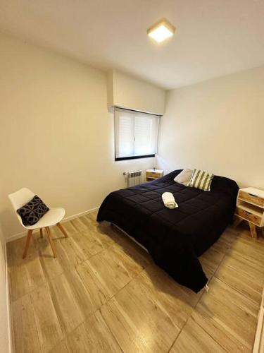 a bedroom with a large black bed and a chair at Casa impecable con Pileta, Garage in Azul