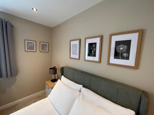 a living room with a green couch and pictures on the wall at Loanside Lodge, Self-Catering, Holm, Orkney. in Saint Marys