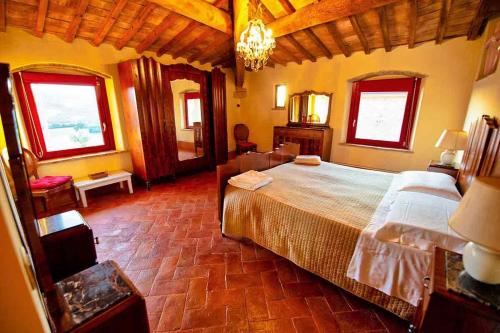 um quarto com uma cama grande e 2 janelas em Podere Calvaiola em Montecatini Val di Cecina