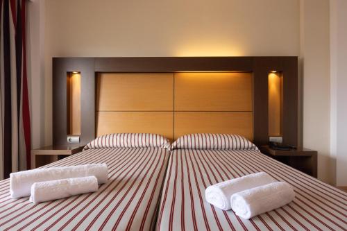 ein Schlafzimmer mit einem großen Bett mit zwei Handtüchern darauf in der Unterkunft Hotel Pabisa Chico in Playa de Palma