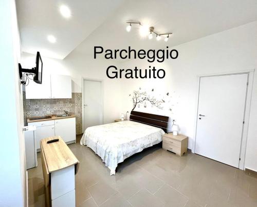 a white bedroom with a bed and a kitchen at Casa Alfrè in Gaeta