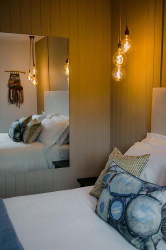 a bedroom with two beds and a mirror at The Deerstone Luxury Eco Hideaway in Laragh