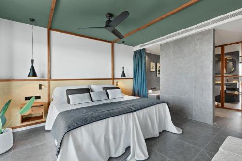 a bedroom with a bed with a ceiling fan at Aubamar Suites & Spa in Playa de Palma