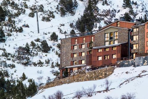 um edifício ao lado de uma montanha coberta de neve em Hotel Roc Meler em Canillo