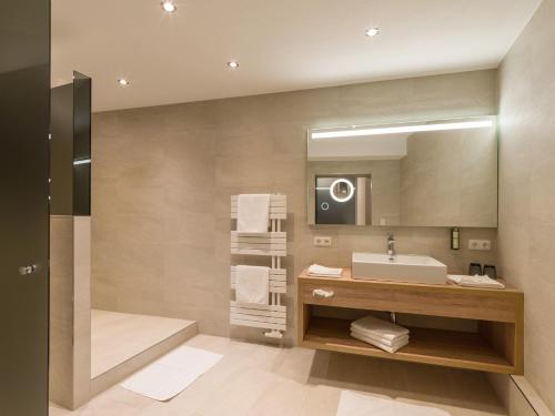 La salle de bains est pourvue d'un lavabo et d'un miroir. dans l'établissement MANNI Chalet, à Mayrhofen