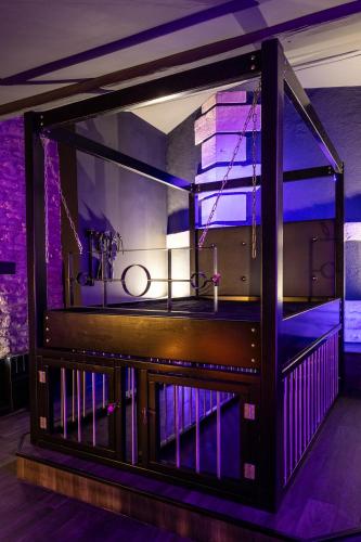 - un grand aquarium dans une chambre avec des lumières violettes dans l'établissement Cherie cherry - romantic and BDSM house, à Briey
