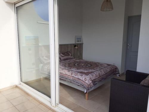 une chambre avec un lit et une porte coulissante en verre dans l'établissement Appartement T2 mezzanine avec piscine., à Saint-Cyprien