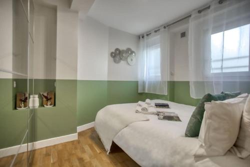 une chambre avec un lit blanc et une fenêtre dans l'établissement Amazing Apart New Bastille 3 Bedrooms 2 Bathrooms, à Paris