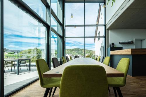 een eetkamer met een tafel en stoelen en een groot raam bij Ferienweingut Ulrike Thul in Leiwen