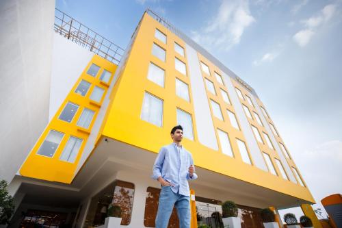 a man standing in front of a yellow building at Bloom Hub - ORR Marathahalli in Bangalore