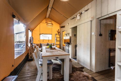 un comedor con mesa y sillas en una casa en Camping Vossenberg - op de Veluwe!, en Epe