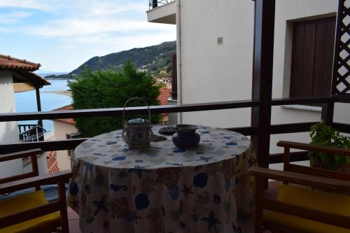 a table on a balcony with a view of the ocean at Alisaxni Seaside Studio in Agios Ioannis Pelio