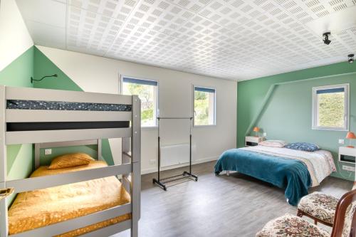 a bedroom with two bunk beds and green walls at Gîte Ruelle aux Vaches - Avec piscine partagée in Montreuil-Bellay