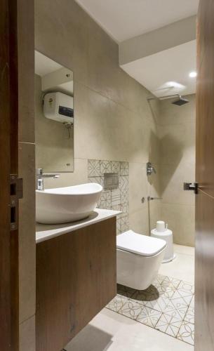 a bathroom with two sinks and a toilet in it at Hotel Maneck Manor in Ooty