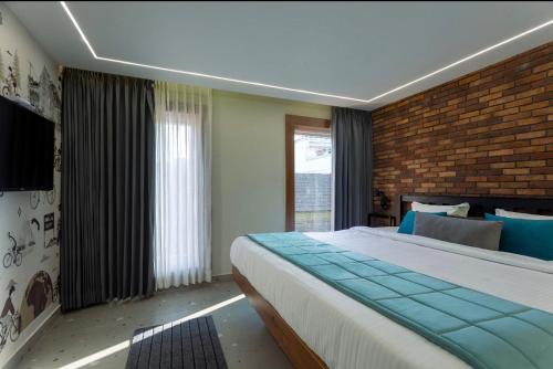 a bedroom with a large bed and a brick wall at Hotel Maneck Manor in Ooty