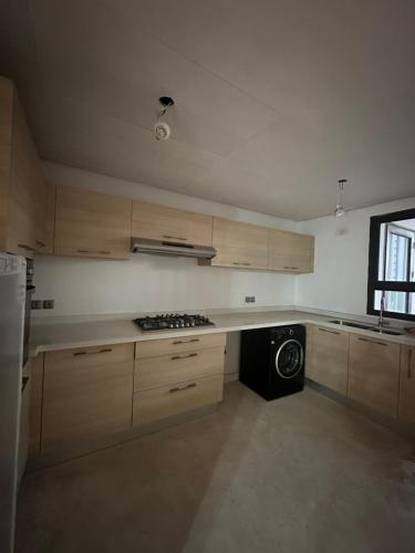 a kitchen with wooden cabinets and a stove top oven at Saphir penthouse ocean view in Casablanca