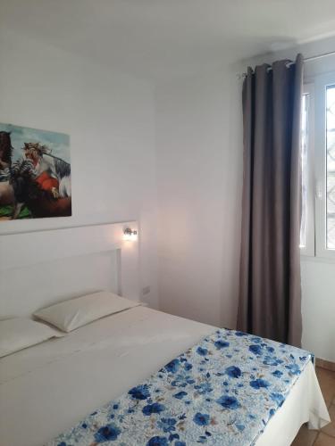 a bedroom with a bed with a painting on the wall at Villa Dei Lidi - HomeSalento com in Torre San Giovanni Ugento