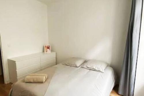 ein weißes Bett in einem weißen Zimmer mit einem Bett sidx sidx sidx in der Unterkunft Bel appartement neuf et facile d'accès in Orléans