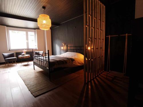 a bedroom with a bed and a room with a window at Le petit Chermont in Saint-Hubert
