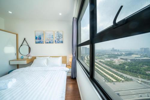 um quarto com uma cama e uma grande janela em Luna's House - Vinhomes D'Capitale - 2Br Apt em Hanói