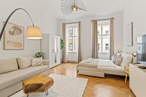een woonkamer met een bank en een tafel bij Cozy Vienna Apartments - 4 Min U6 Josefstädterstraße in Wenen