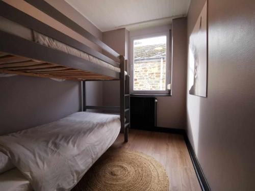 a bedroom with two bunk beds and a window at Le petit Chermont in Saint-Hubert