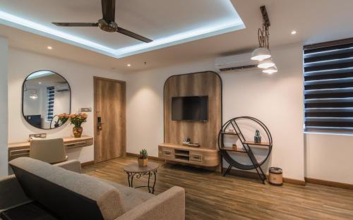 a living room with a couch and a tv at Aaron Boutique Hotel in Nha Trang