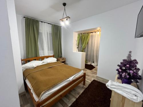 a bedroom with a bed and a christmas tree in it at Pensiunea Alexia in Petroşani