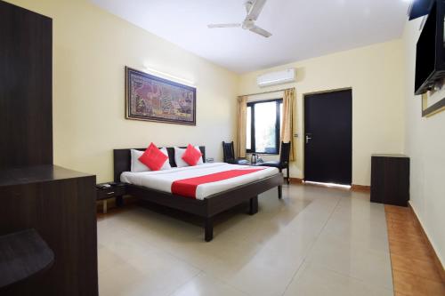 a bedroom with a bed with red pillows at OYO 24408 Nirmala Guest House in Jodhpur