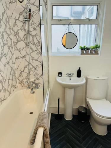 a bathroom with a toilet and a sink at 2 Bedrooms House near Central London in London