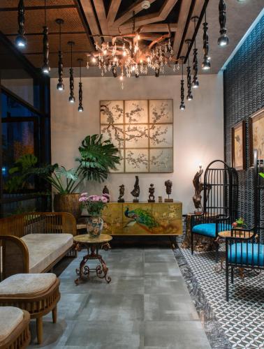 a room with chairs and tables and a chandelier at Aaron Boutique Hotel in Nha Trang