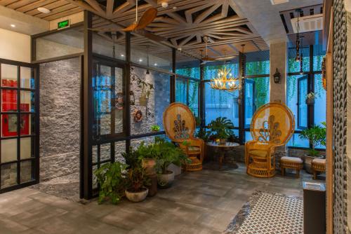 a restaurant with chairs and plants in a room at Aaron Boutique Hotel in Nha Trang