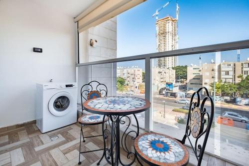 a balcony with a table and chairs and a washing machine at Studio Unit in Ashdod Israel in Ashdod