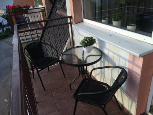a table and chairs on a balcony with a window at Apartament Slupsk in Słupsk