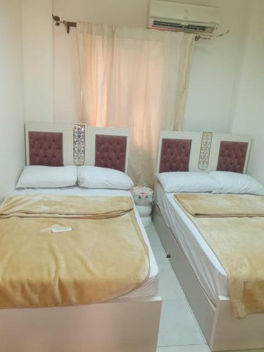 - deux lits assis l'un à côté de l'autre dans une pièce dans l'établissement مكادى هايتس, à Hurghada