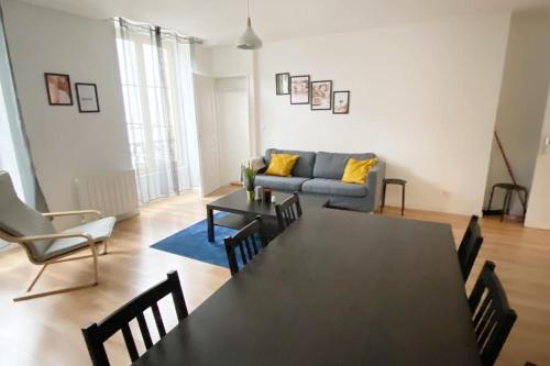 un salon avec une table noire et un canapé dans l'établissement Appartement 4 chambres spacieux et lumineux, à Orléans