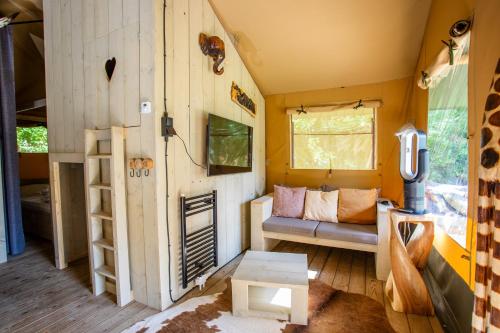 a living room of a tiny house with a couch at Camping Vossenberg - op de Veluwe! in Epe