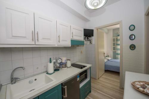 - une cuisine avec des placards bleus et blancs et un évier dans l'établissement Villa Areti, à Astrakeri