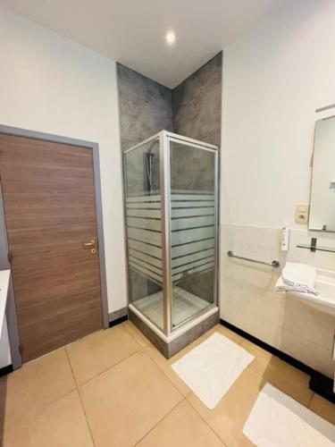 a bathroom with a glass shower and a sink at Parkhotel Gent Centrum in Ghent