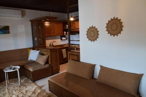 ein Wohnzimmer mit einem Sofa und einer Küche in der Unterkunft Alisaxni Seaside Studio in Agios Ioannis