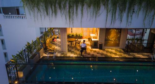 a woman is standing next to a swimming pool at Aaron Boutique Hotel in Nha Trang