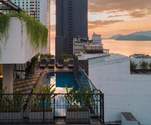 a pool on the rooftop of a building with a view of the water at Aaron Boutique Hotel in Nha Trang