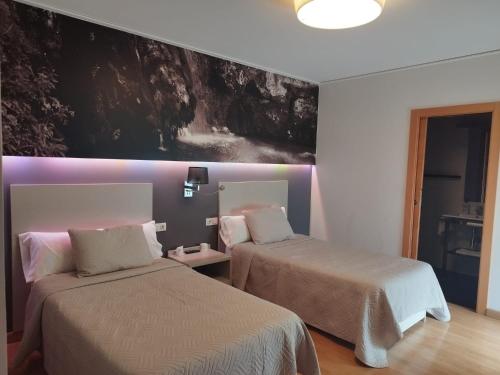um quarto com duas camas e um quadro na parede em Hello Villarreal Suites em Villareal