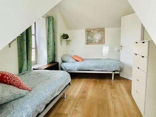 twee bedden in een kleine kamer met houten vloeren bij Face Mer Villa Le Petit Breton in Pornichet