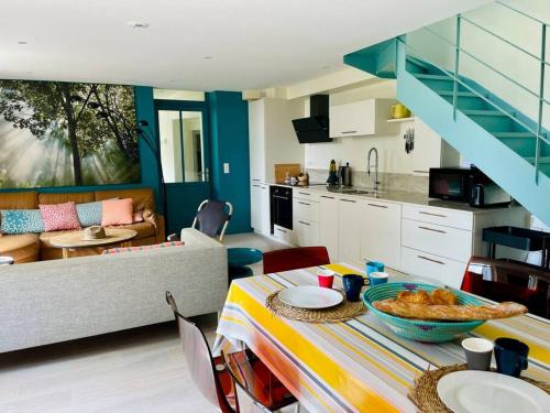 uma cozinha e sala de estar com uma mesa com uma tigela de comida em Face Mer Villa Le Petit Breton em Pornichet