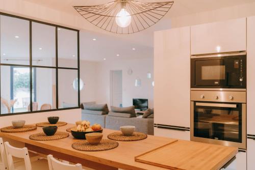 Il comprend une cuisine et un salon avec une table en bois. dans l'établissement 100m de la plage - Belle maison pour 8, à Pornichet