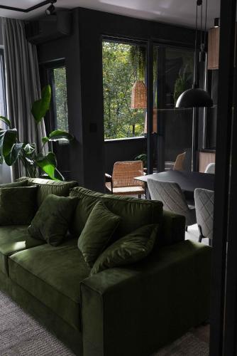 a living room with a green couch and a table at ZEST Verde in Kragujevac